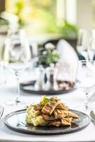 weens schnitzel besnoeiing in stroken en gestileerd Aan een aardappel salade in de restaurant foto