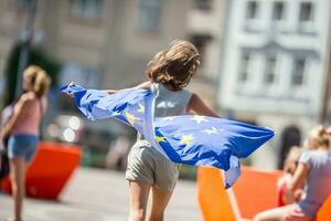 schattig gelukkig jong meisje met de vlag van de Europese unie foto