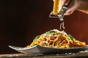 Italiaans pasta spaghetti met tomaat saus basilicum en Parmezaanse kaas kaas in wit bord foto