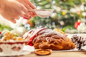 man's hand- sprenkeling suikerglazuur suiker over- vers Kerstmis taart - vanocka. foto