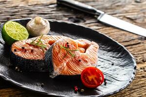 Zalm rauw steaks rozemarijn tomaten paddestoel limoen olijf- olie en specerijen. foto