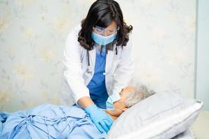 arts die stethoscoop gebruikt om aziatische senior of oudere oude dame vrouw patiënt te controleren die een gezichtsmasker draagt in het ziekenhuis ter bescherming van infectie covid-19 coronavirus.