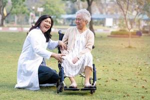 arts hulp en zorg Aziatische senior of oudere oude dame vrouw patiënt zittend op rolstoel in park in verpleeg ziekenhuisafdeling gezond sterk medisch concept foto