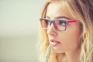 Universiteit leerling meisje nadenkend met pen Aan haar lippen. portret van denken vrouw met bril. foto