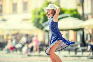 mooi schattig jong meisje dansen Aan de straat van geluk.schattig gelukkig meisje in zomer kleren dansen in de zon. foto