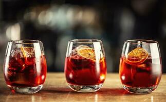 negroni klassiek cocktail en gin kort drinken met zoet vermout, rood bitter likeur en droog oranje garneer foto