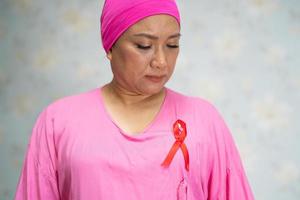 aziatische dame vrouw patiënt pijn en zorgen over haar borst in het ziekenhuis, symbool van de werelddag van borstkanker. foto