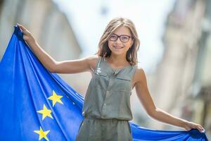 schattig gelukkig jong meisje met de vlag van de Europese unie foto