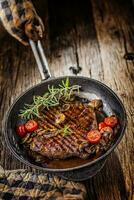 rundvlees steak. rooster rundvlees flank steak met rozemarijn musrooms en tomaten in pan foto