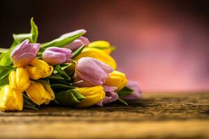 tulpen. boeket van voorjaar tulpen geel en roze Aan houten tafel foto