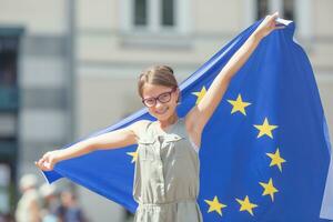 schattig gelukkig jong meisje met de vlag van de Europese unie foto