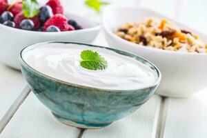 muesli yoghurt en bessen. gezond ontbijt met yoghurt muesli en vers fruit foto