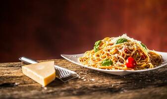 Italiaans pasta spaghetti met tomaat saus basilicum en Parmezaanse kaas kaas in wit bord foto