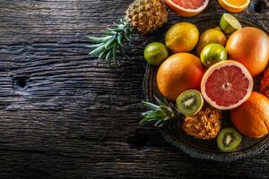 top visie van exotisch fruit en citrusvruchten Aan een wijnoogst hout foto