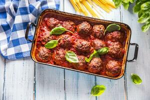 heerlijk Italiaans maaltijd vlees rundvlees ballen met pasta spaghetti en basilicum in wijnoogst brander pan foto