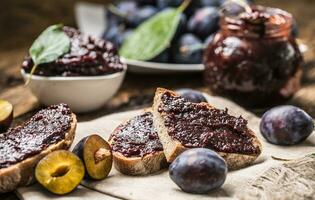 ontbijt van eigengemaakt Pruim jam brood en rijp pruimen. foto