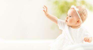 banier visie van een klein baby meisje bereiken met een hand- in de lucht foto