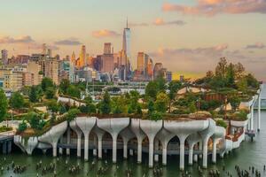 stadsgezicht van downtown Manhattan horizon met de weinig eiland openbaar park in nieuw york stad Bij zonsopkomst foto