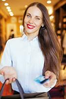 een vrouw Holding een credit kaart en boodschappen doen Tassen foto