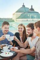 vier mensen zittend Bij een tafel met koffie cups foto