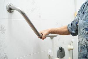 Aziatische senior of oudere oude dame vrouw patiënt gebruik toilet badkamer handvat beveiliging in verpleegafdeling ziekenhuis, gezond sterk medisch concept.