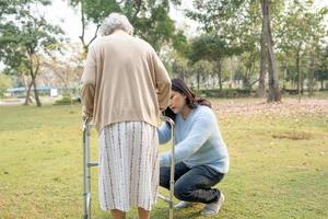 help en zorg aziatische senior of oudere oude dame vrouw gebruik rollator met een sterke gezondheid tijdens het wandelen in het park in een fijne frisse vakantie.