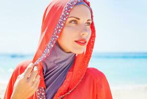 mooi moslim Kaukasisch Russisch vrouw vervelend rood jurk ontspannende Aan een strand foto