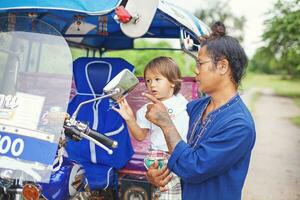 een Mens en een kind zijn op zoek Bij een motorfiets foto