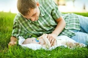 een Mens houdende Aan de gras met zijn baby foto