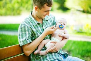 een Mens Holding een baby terwijl zittend Aan een bank foto