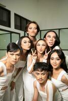 een groep van Aziatisch dansers krijgen samen en maken dwaas gezichten terwijl nemen afbeeldingen Aan de dans verdieping foto