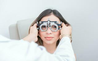 oogarts onderzoeken geduldig met optometrist beproeving kader. dokter aanpassen visie van geduldig met optometrist beproeving kader foto