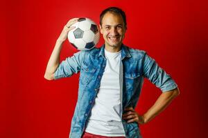 knap Mens Holding een voetbal bal over- kleurrijk achtergrondkleur foto