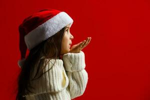 schattig weinig meisje in de de kerstman claus hoed foto