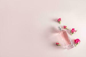 een chique kristal fles van kunstmatig verstuiven of vrouwen parfum Aan een roze achtergrond met klein bloemknoppen van roze rozen. ruimte voor tekst. top visie. foto