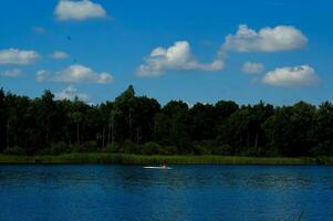 zomer landschap met een meer en een boot Aan een warm zomer dag foto
