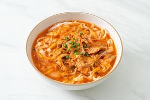 Koreaanse udon ramen-noedels met varkensvlees in kimchi-soep foto