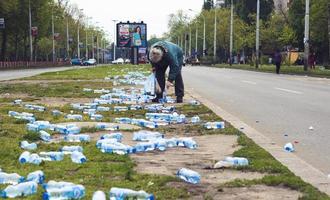 Belgrado, Servië, 22 april 2017 - vrouw verzamelt flessen water weggegooid na marathon foto