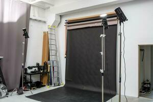 interieur van helder ruimte van foto studio met groot zwart achtergrond en verlichting uitrusting