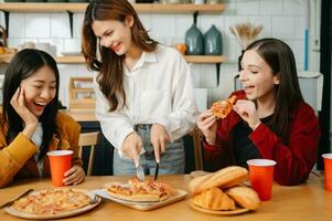 groep van vrienden maken pret Bij huis partij.zij zittend Aan bureau in leven kamer en aan het eten pizza. gelukkig foto