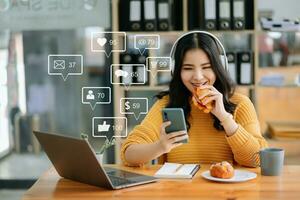 Aziatisch vrouw typen smartphone, toetsenbord met laptop computer van sociaal media en afzet virtueel pictogrammen scherm concept. foto