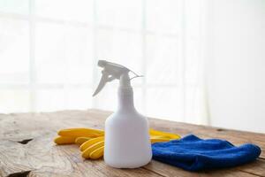 blauw handdoek en geel handschoenen waren geplaatst Aan houten tafel voor schoonmaak personeel naar gebruik naar schoon en voorkomen schoonmaakster van dermatitis. concept van kiezen schoonmaak bedrijf naar schoon de kantoor foto