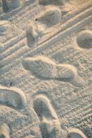 de achtergrond van een zanderig strand met voetafdrukken. zand strand achtergrond foto