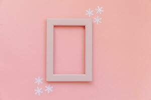 eenvoudig minimaal samenstelling winter voorwerpen roze kader sneeuwvlokken geïsoleerd Aan roze pastel achtergrond foto