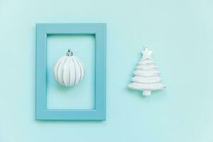 eenvoudig minimaal samenstelling winter voorwerpen ornament Spar boom bal in blauw kader geïsoleerd Aan blauw pastel modieus achtergrond foto