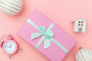 eenvoudig minimaal samenstelling winter voorwerpen ornament slee Spar boom bal geschenk doos geïsoleerd Aan roze pastel modieus achtergrond foto