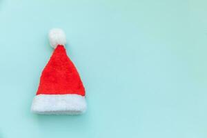 eenvoudig minimaal ontwerp Kerstmis de kerstman claus hoed geïsoleerd Aan blauw pastel kleurrijk modieus achtergrond foto
