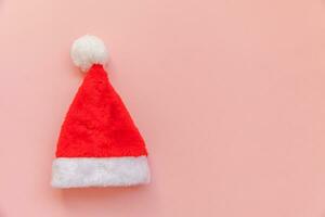 eenvoudig minimaal ontwerp Kerstmis de kerstman claus hoed geïsoleerd Aan roze pastel kleurrijk modieus achtergrond foto