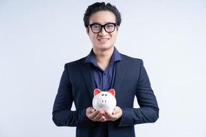 portret van aziatische zakenman die spaarvarken houdt foto