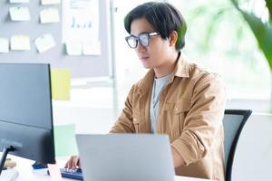 Aziatische zakenman aan het werk met laptop op kantoor